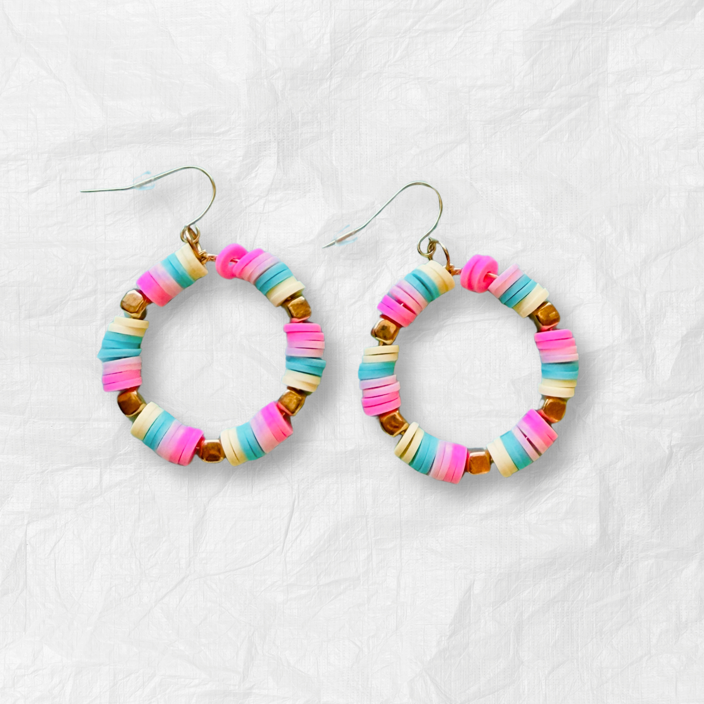 A pair of hot pink, pastel pink, teal, and yellow hoop earrings with gold accents, inspired by cotton candy, for a fun and whimsical jewelry statement.