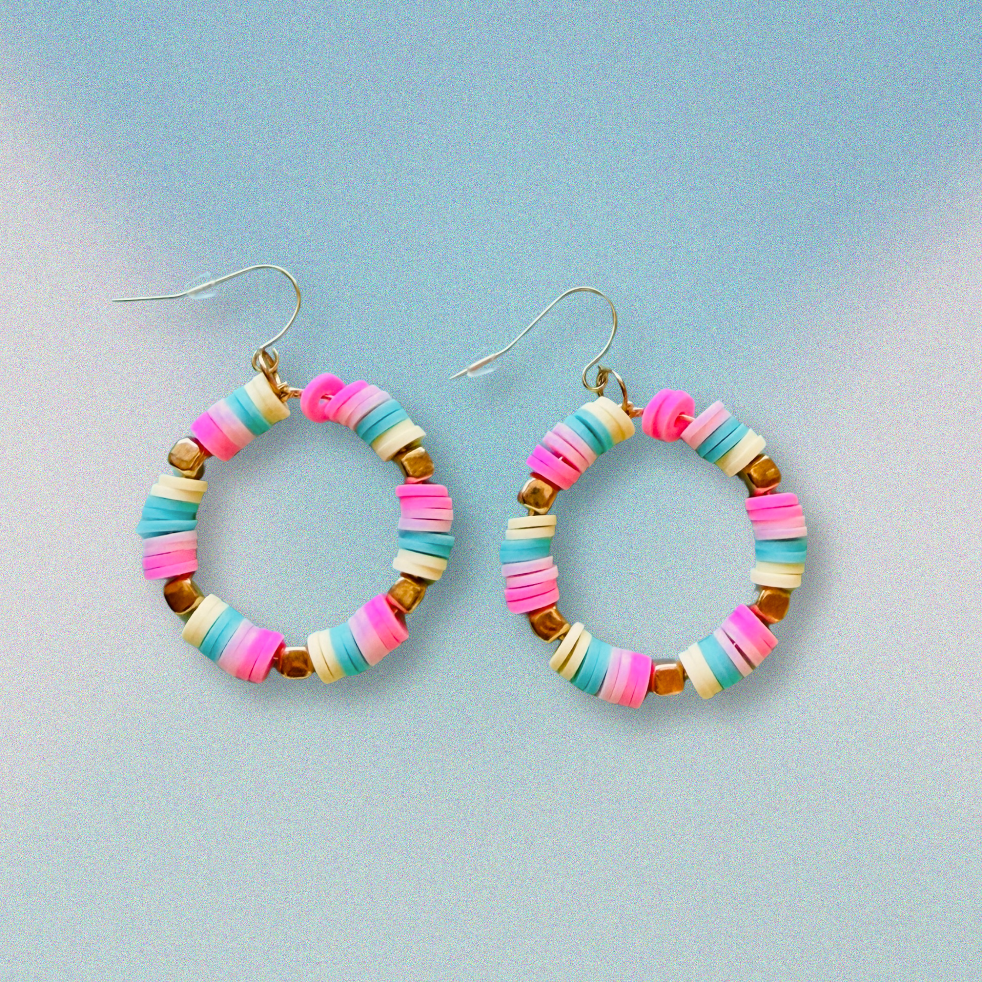 A pair of hot pink, pastel pink, teal, and yellow hoop earrings with gold accents, inspired by cotton candy, for a fun and whimsical jewelry statement.