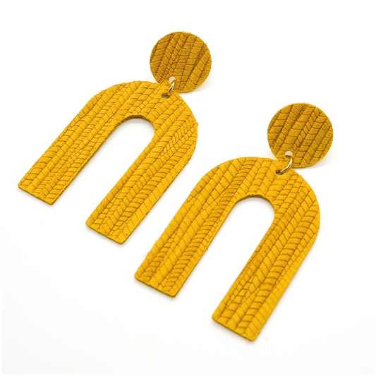 Bold statement earrings in vibrant colors, lightweight and comfortable for all-day wear, handcrafted sustainable leather earrings, eco-friendly jewelry with modern designs, festive holiday earrings perfect for gifting, celestial sun and moon motifs, boho styles with earthy tones, playful Dalmatian print earrings, minimalist earrings styled for the season, bold designs from a small, women-owned business, gift-worthy feather-light earrings, sustainable and recycled leather for eco-conscious fashion