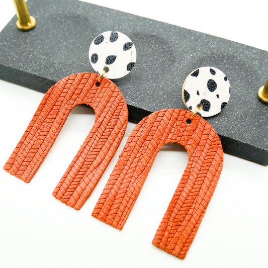 Bold statement earrings in vibrant colors, lightweight and comfortable for all-day wear, handcrafted sustainable leather earrings, eco-friendly jewelry with modern designs, festive holiday earrings perfect for gifting, celestial sun and moon motifs, boho styles with earthy tones, playful Dalmatian print earrings, minimalist earrings styled for the season, bold designs from a small, women-owned business, gift-worthy feather-light earrings, sustainable and recycled leather for eco-conscious fashion
